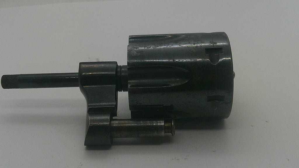 A used dark metallic mechanical part, possibly a motor or gear assembly, photographed on a plain light gray background.