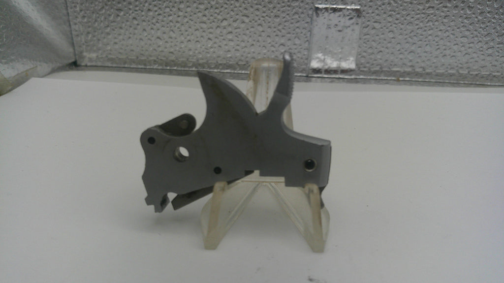 Metal mechanical part on a stand against a textured wall background