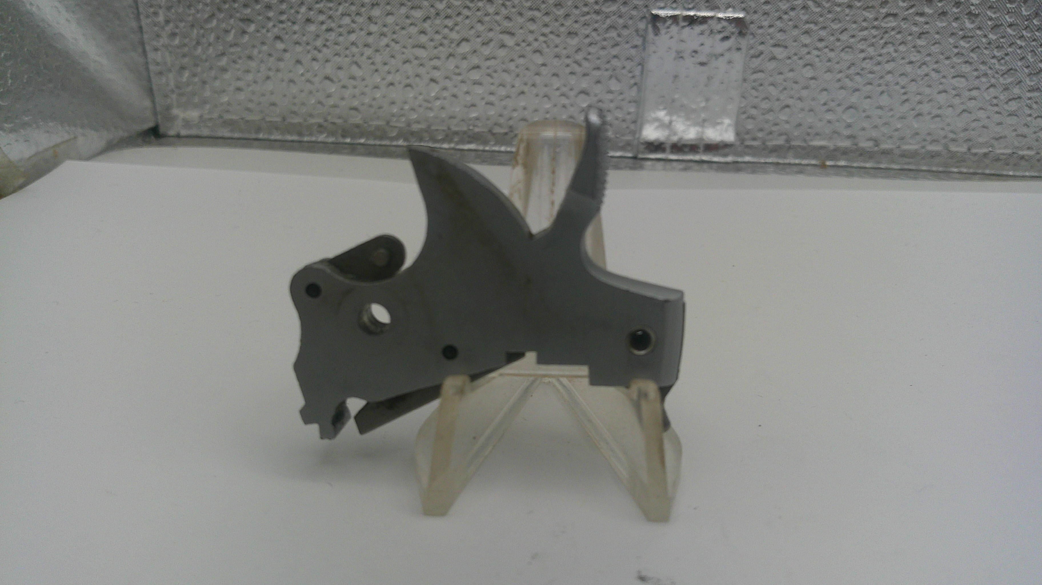 Metal mechanical part on a stand against a textured wall background