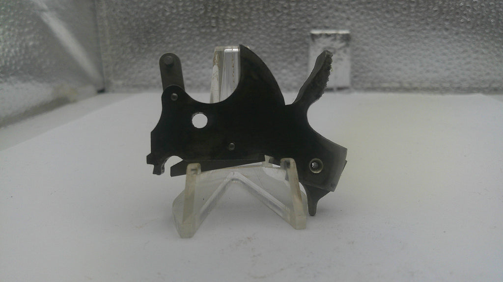 Black metal bracket on a clear stand against a textured white background