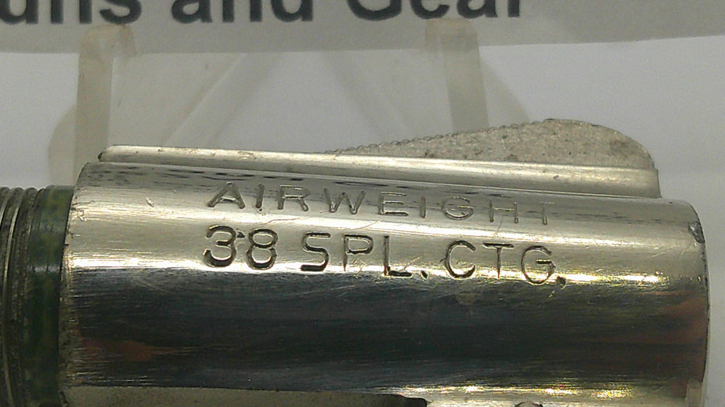 A close-up of a metallic cylindrical component with engraved text reading 'AIRWEIGHT 38 SPL CTG.' on a light background.