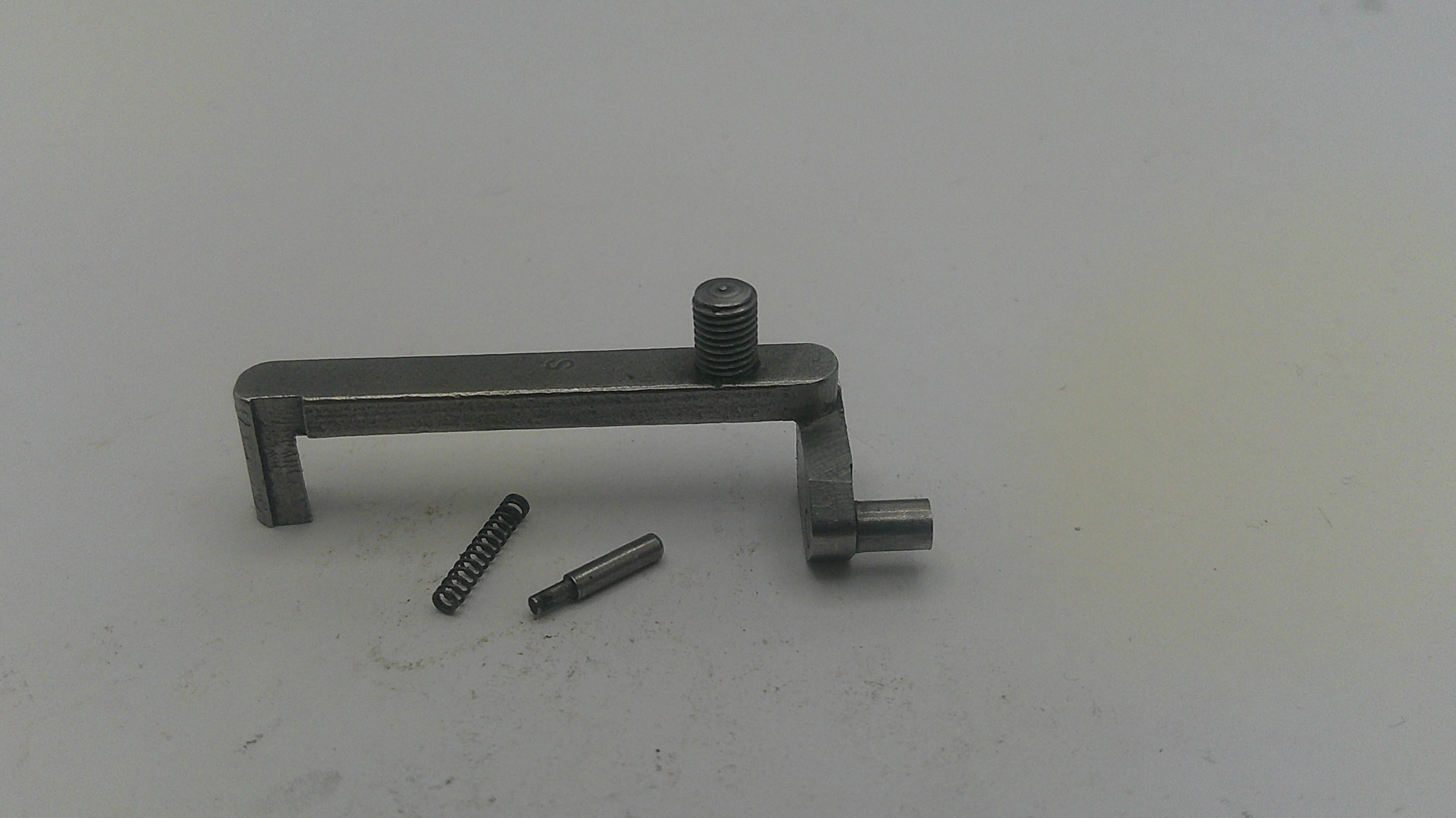 Metal tool with two small components on a light gray background