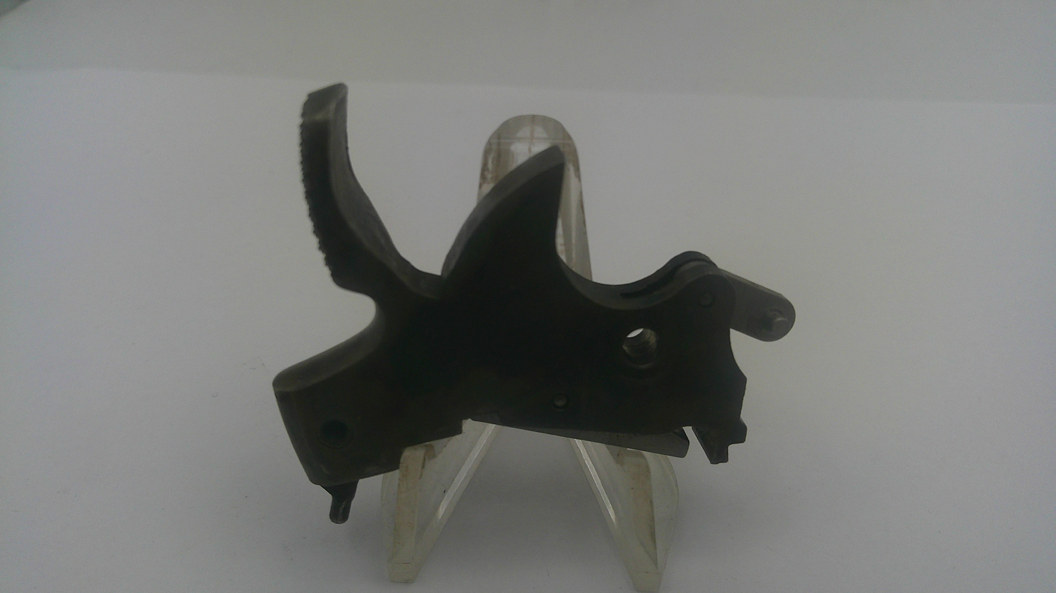 A black metal trigger assembly for a firearm, displayed on a clear plastic stand against a plain light gray background.