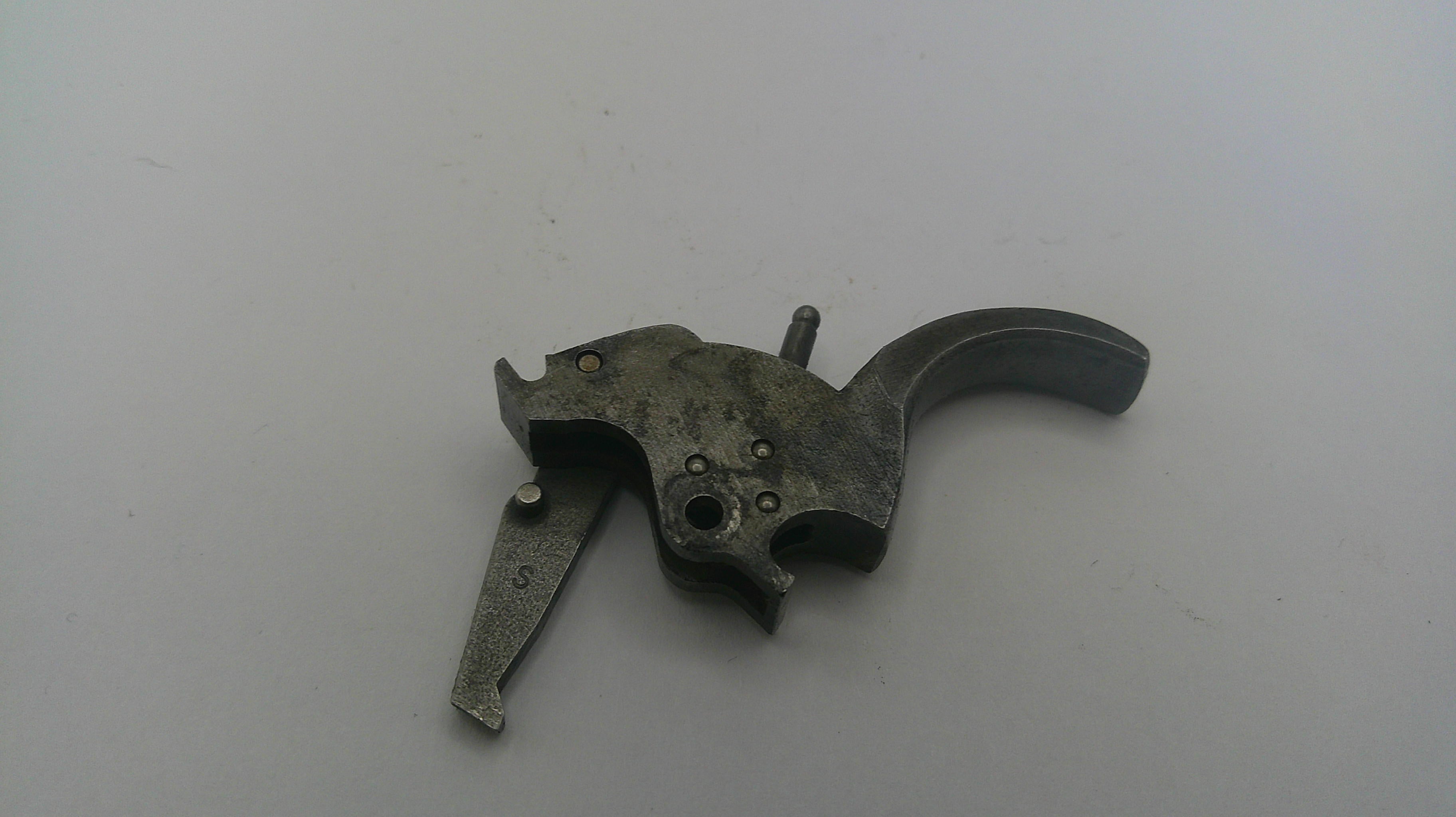 Metallic firearm trigger on a white background