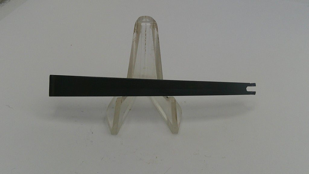 Black metal strip on a clear stand against a white background