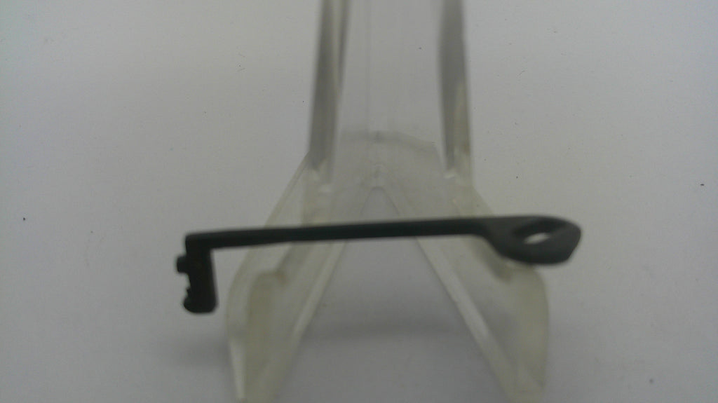 A small black metal key or lock pick with a looped end, displayed on a clear plastic stand against a plain light background.