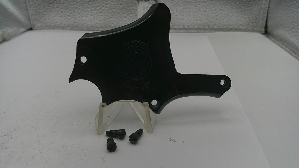 Black plastic car part on a white surface with screws