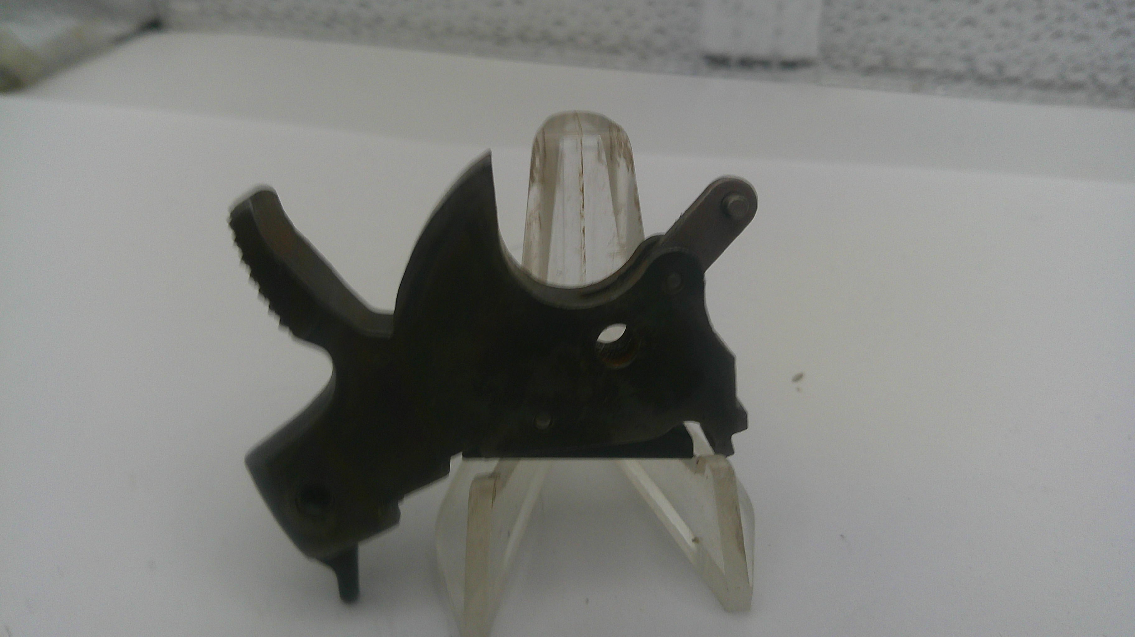 Black metal bracket on a white stand with a textured background