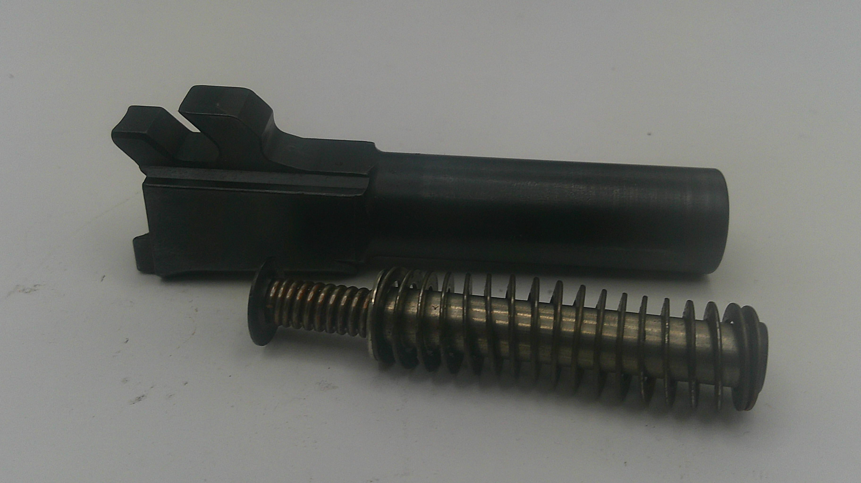A black metal receiver or grip component with a threaded spring attached, photographed on a plain light gray background.