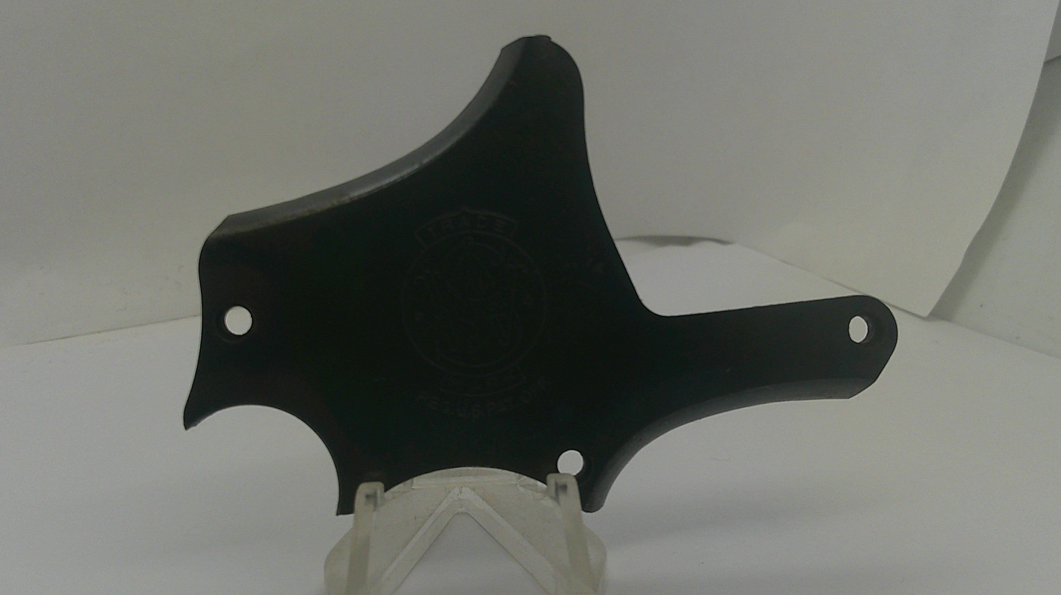 A black plastic mounting bracket or cover with pre-drilled holes, displayed on a clear plastic stand against a white background.