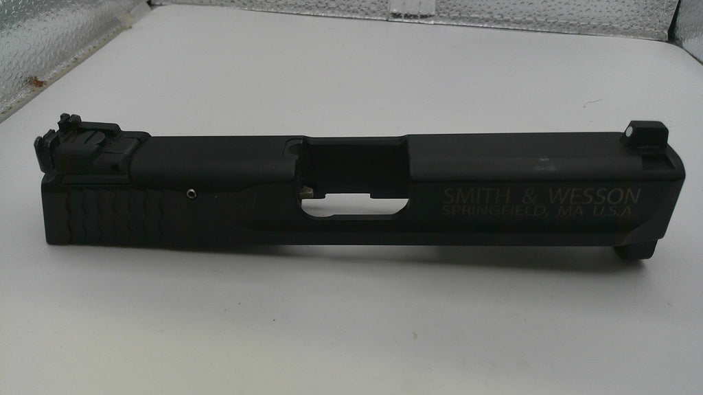 Black firearm slide with 'Smith & Wesson' branding on a white surface.