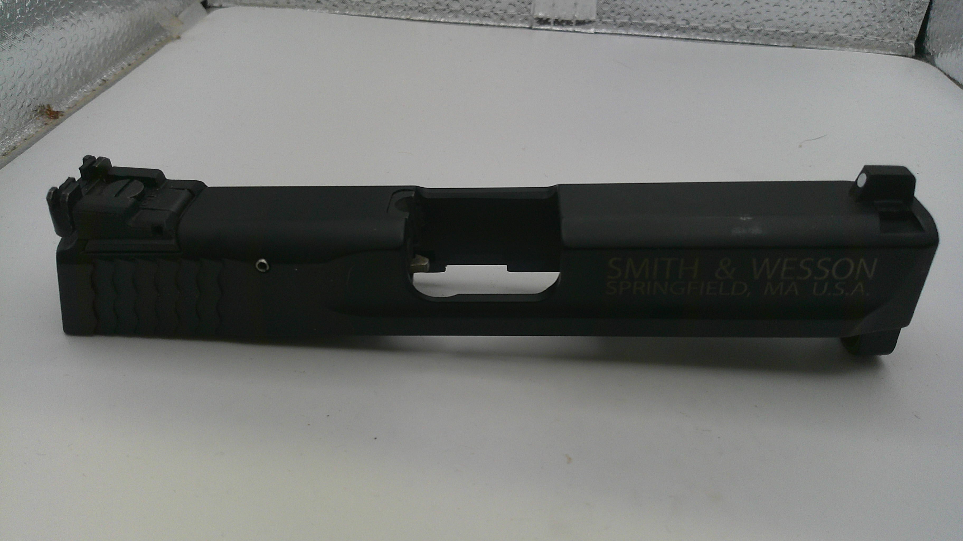 Black firearm slide with 'Smith & Wesson' branding on a white surface.