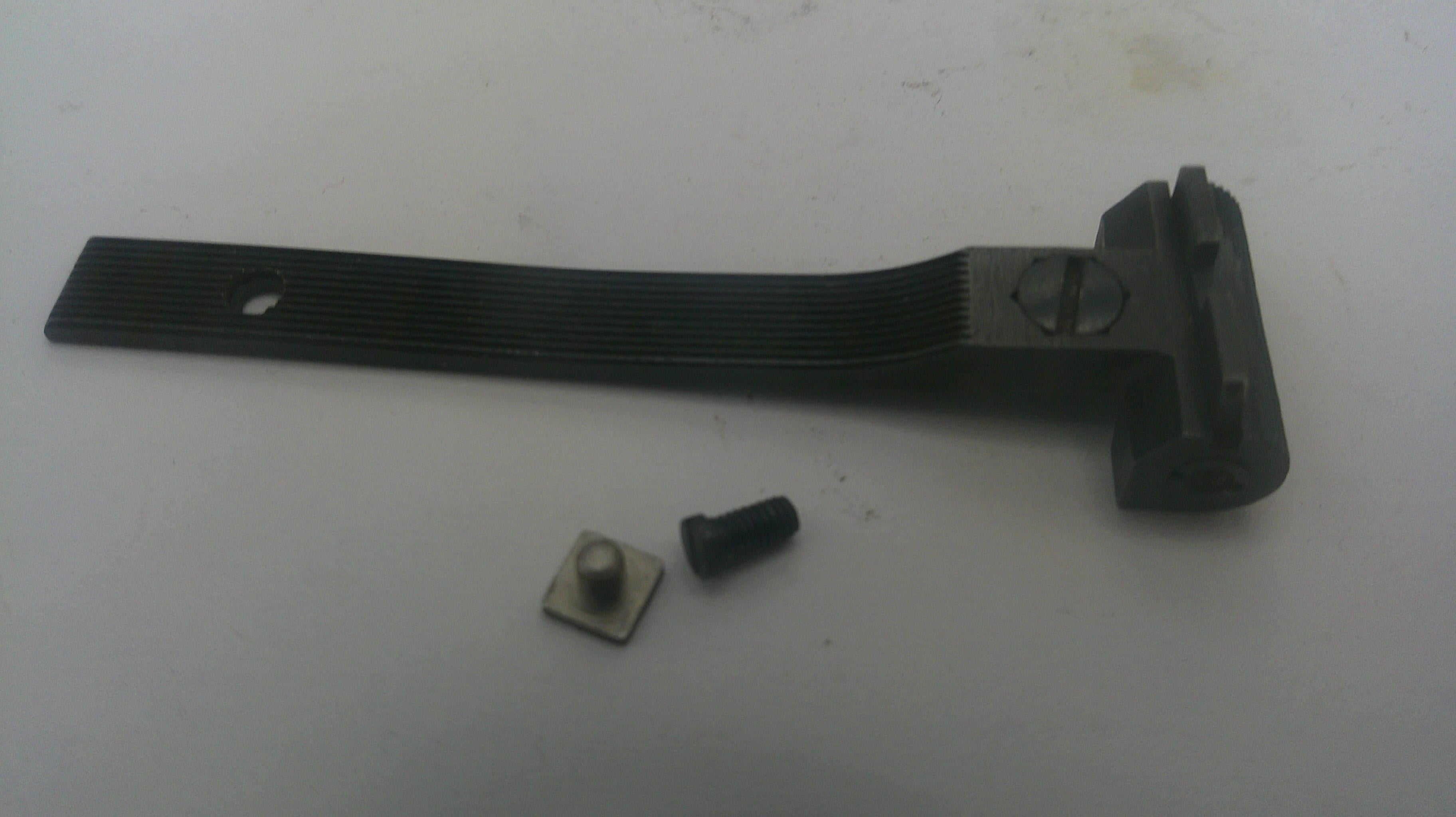 A black metal mounting bracket with a ribbed flat section and a mounting tab, shown with two small hardware components on a light gray surface.