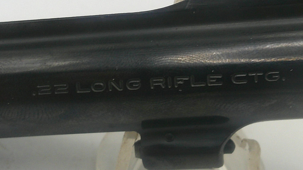 Close-up of a black firearm with '22 Long Rifle Ctg.' engraving on a white background