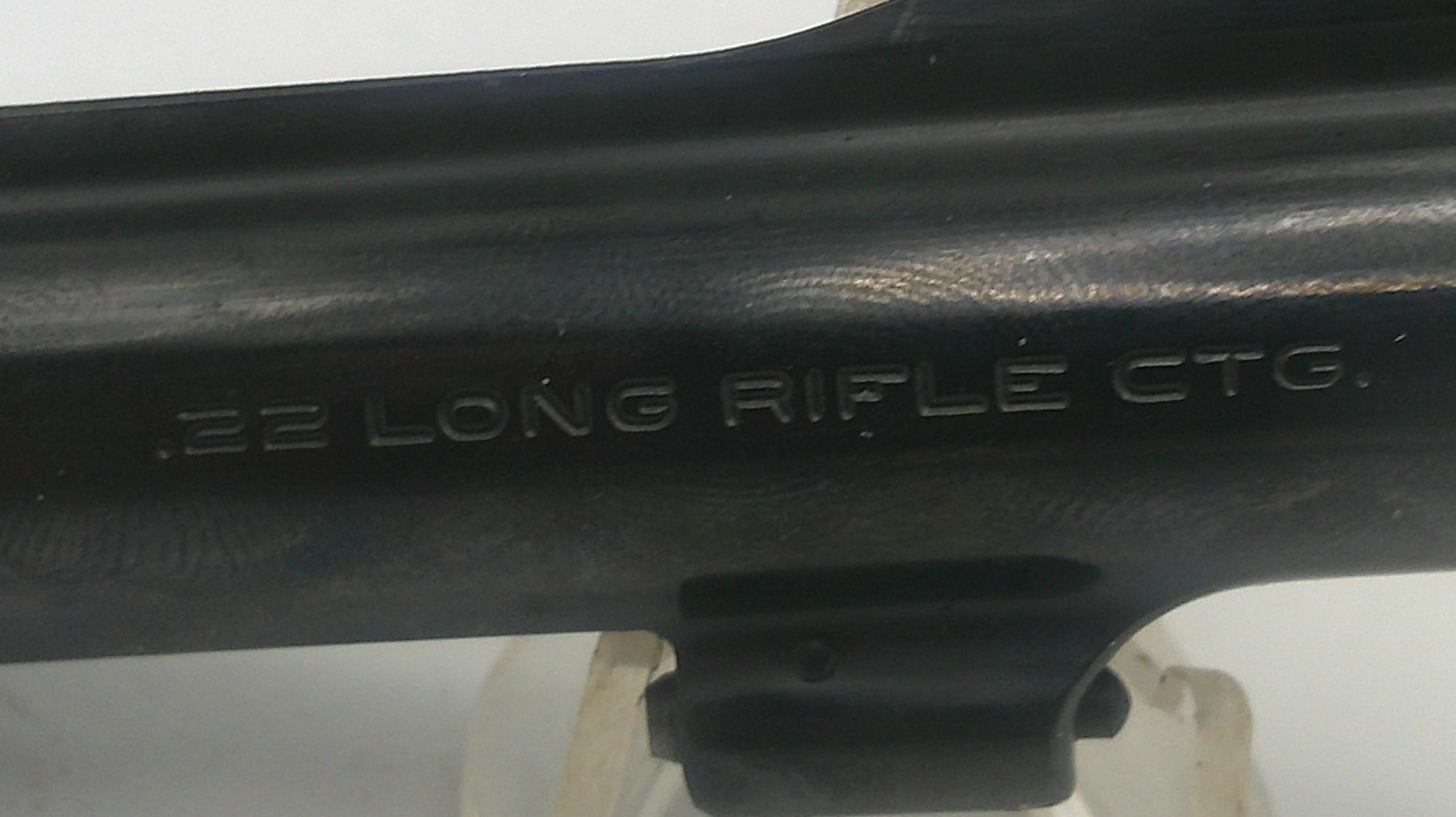 Close-up of a black firearm with '22 Long Rifle Ctg.' engraving on a white background