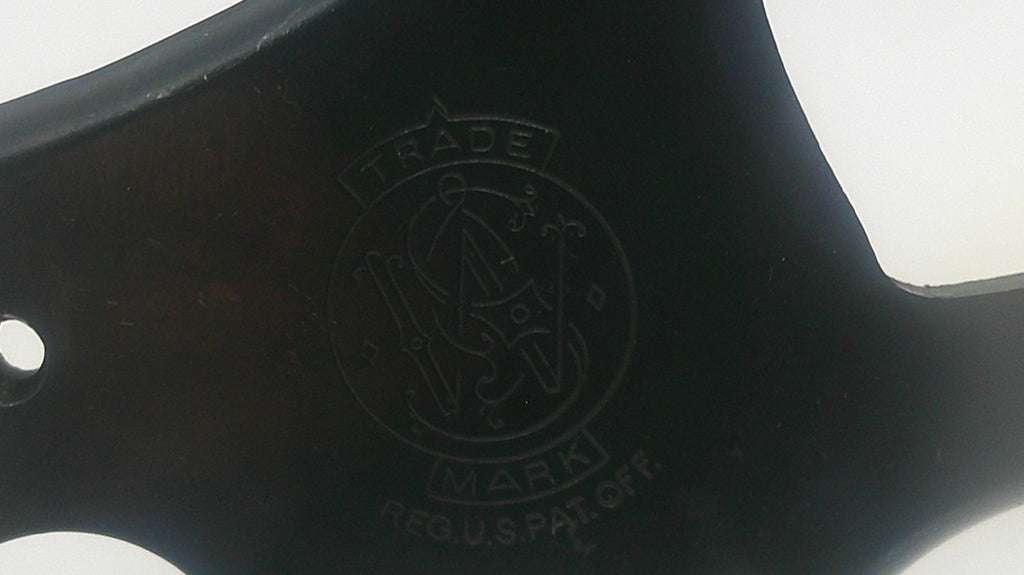 Close-up of a black axe handle with a logo and text.