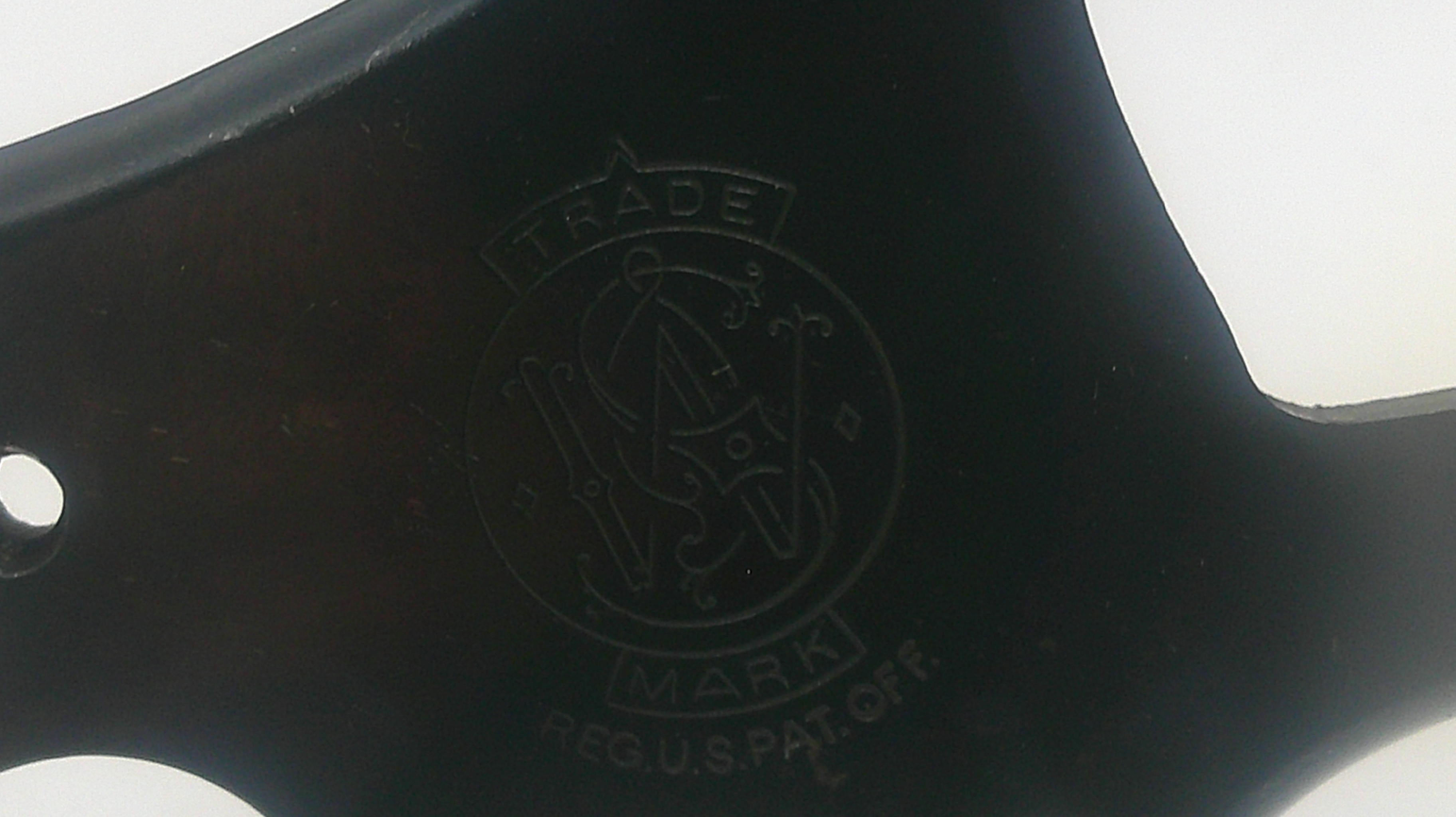 Close-up of a black axe handle with a logo and text.