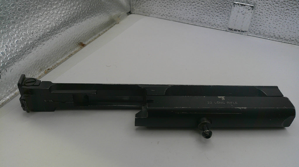 Black metal component on a white surface with a textured wall background
