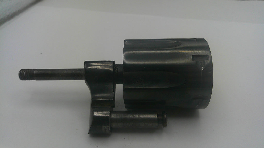 A dark metallic mechanical part, possibly a lock cylinder or hardware component, photographed on a plain white surface.