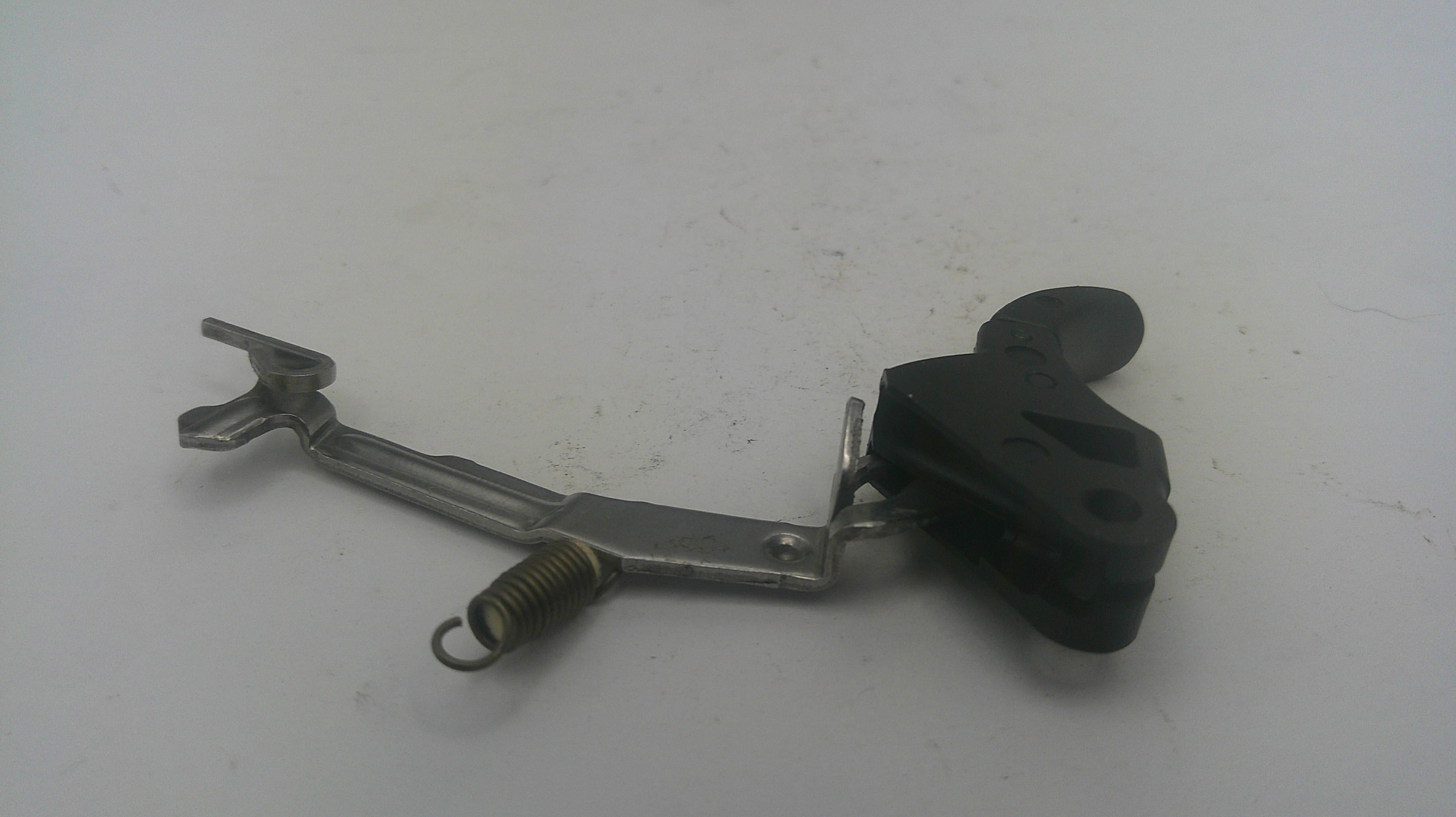 A used mechanical motorcycle or bicycle lever assembly with a black plastic grip, silver metal arm, and a small coiled spring, shown on a plain light gray surface.