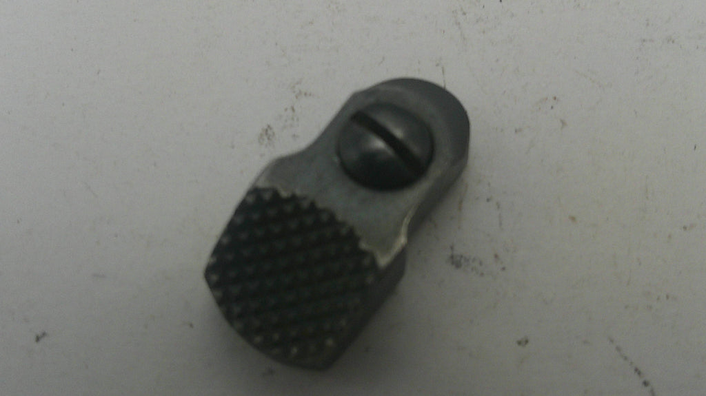 Small metallic object with textured surface on a light gray background