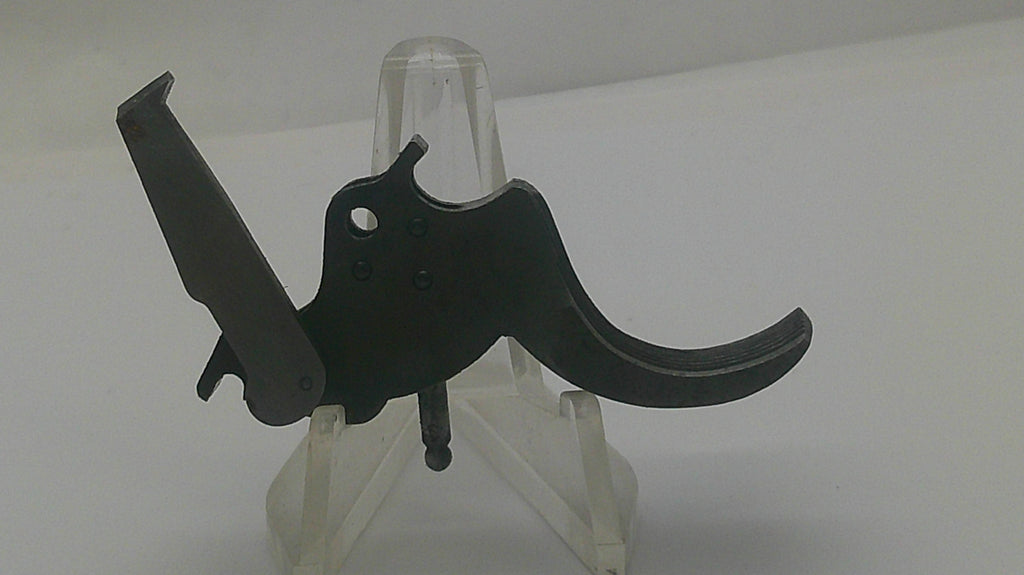 A black metal trigger assembly, likely for a firearm, displayed on a clear plastic stand against a plain white background.