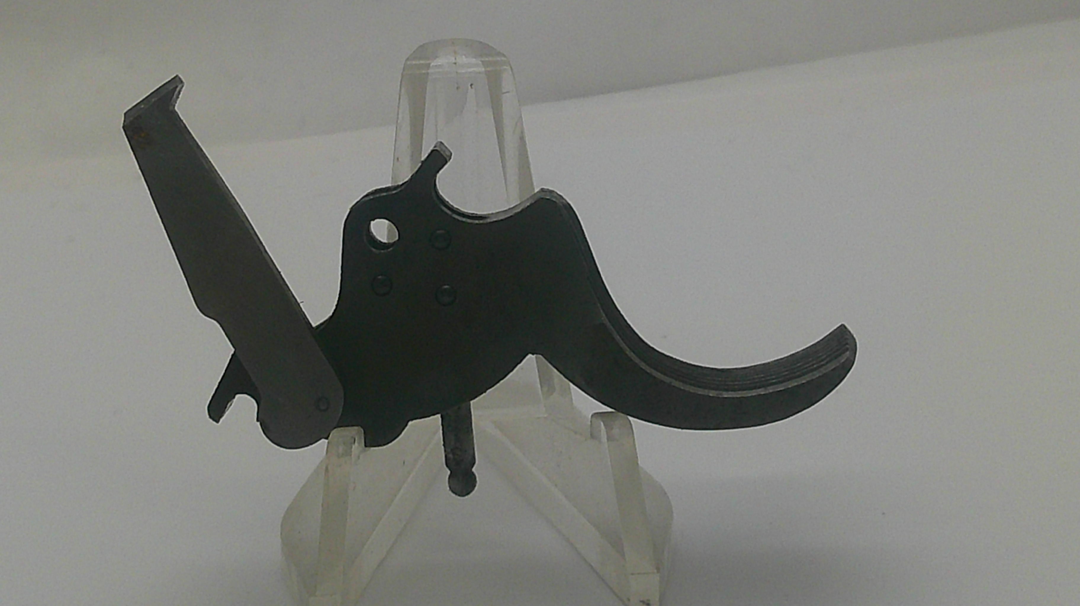 A black metal trigger assembly, likely for a firearm, displayed on a clear plastic stand against a plain white background.