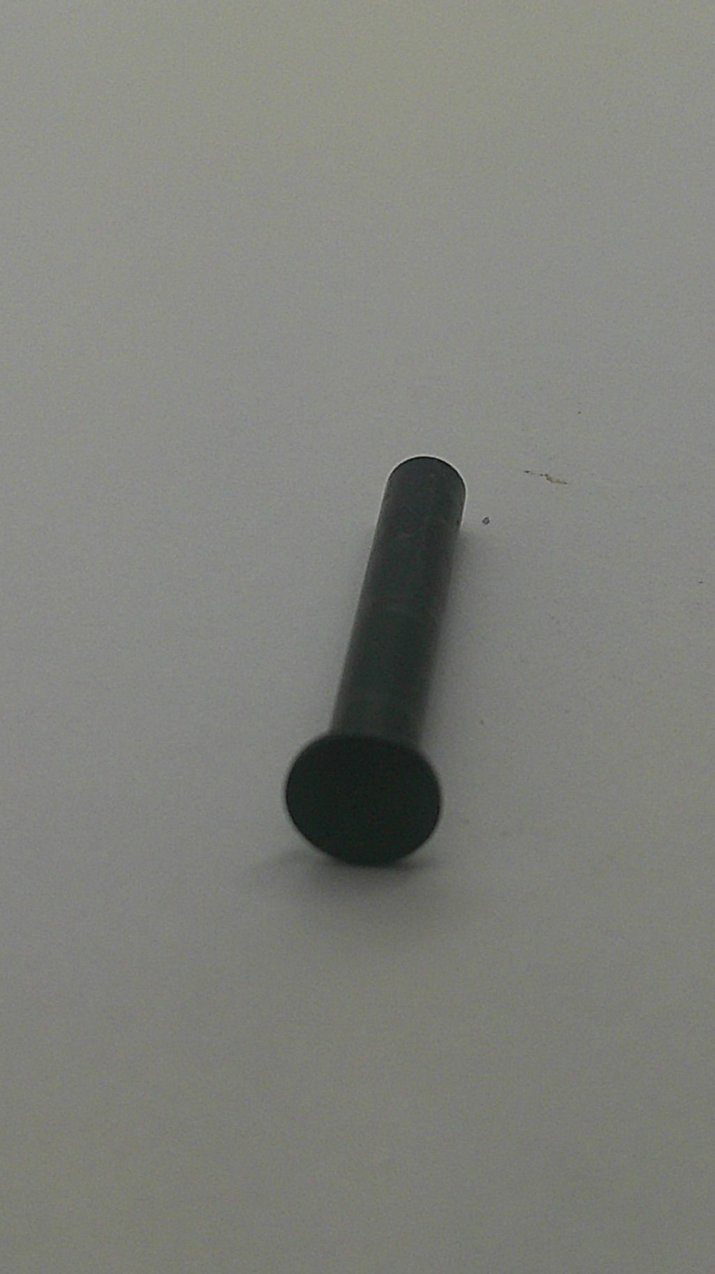 A small black cylindrical pin or fastener with a round head, shown on a plain light gray background.