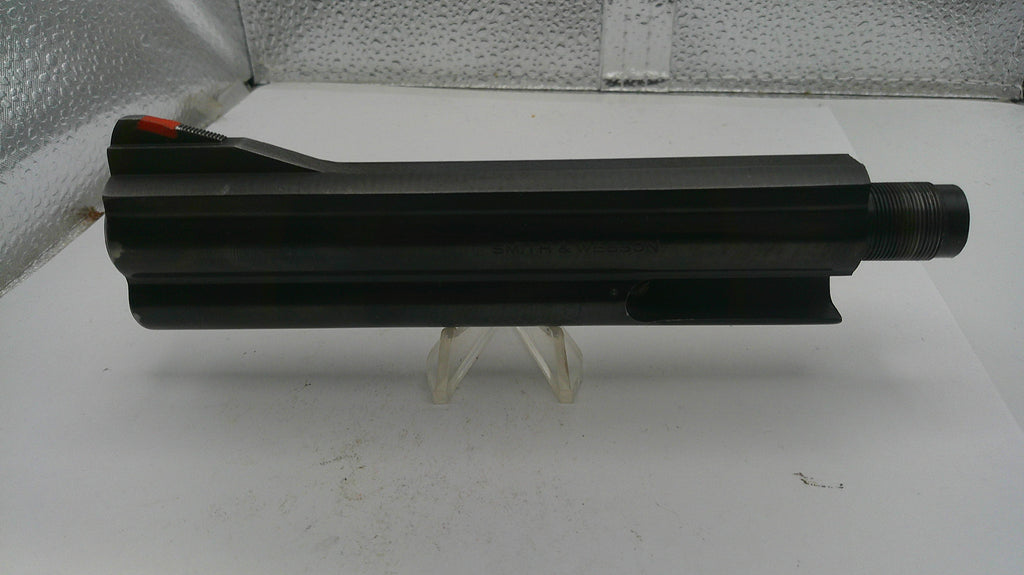 Black cylindrical object on a white surface with a textured background