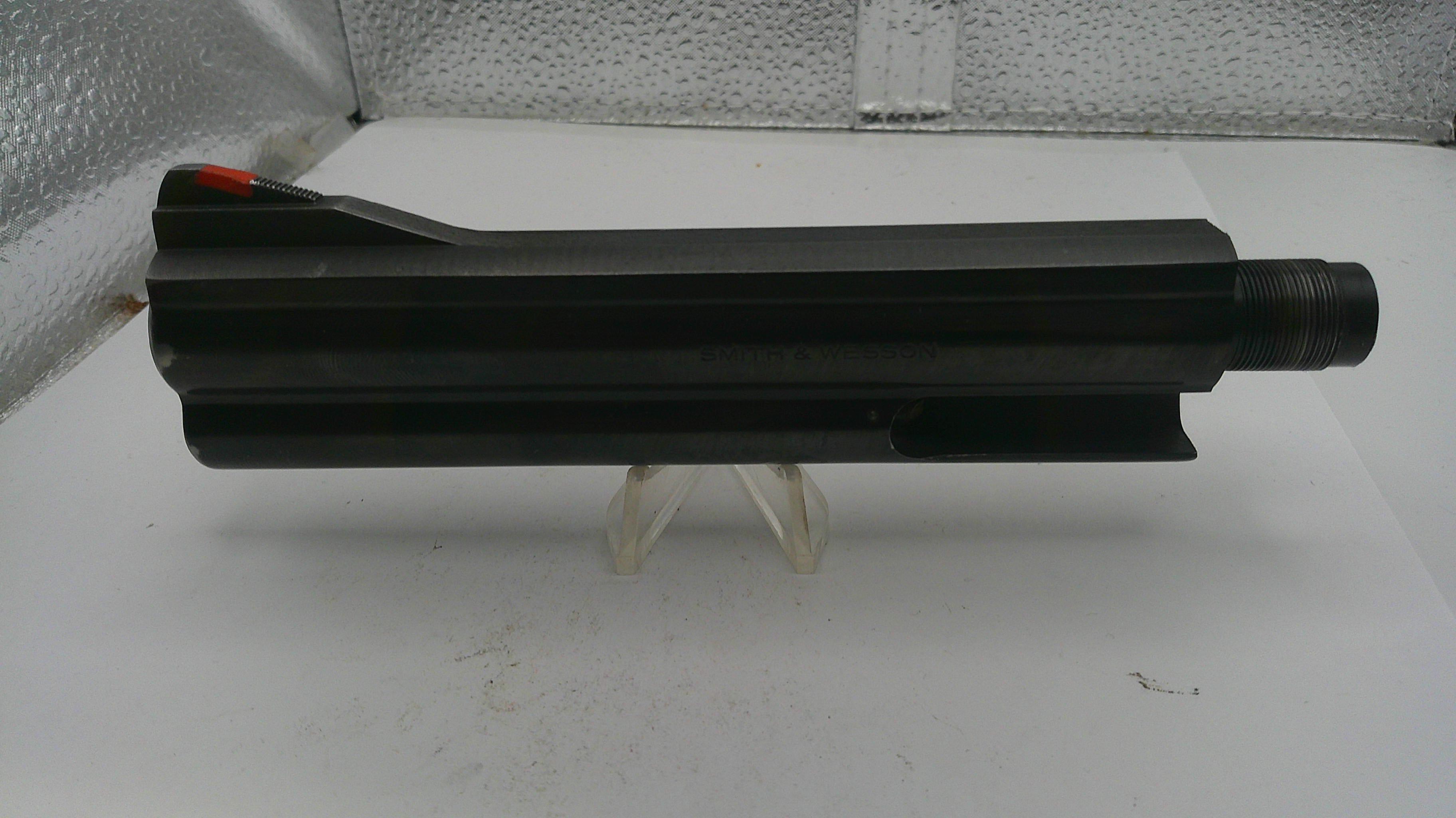 Black cylindrical object on a white surface with a textured background