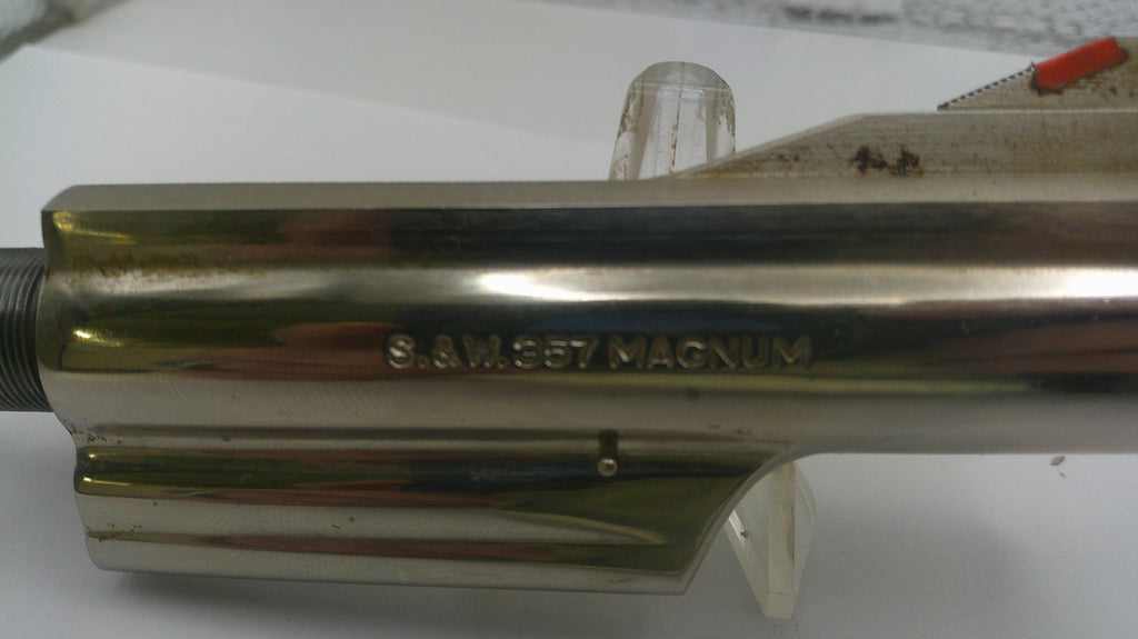 Metallic cylindrical object with 'S&W 357 Magnum' engraving on a white background