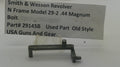 A used metal gun part, specifically a Smith & Wesson Revolver bolt spring plunger, displayed on a white surface with a paper label in the background containing part number 29145B.