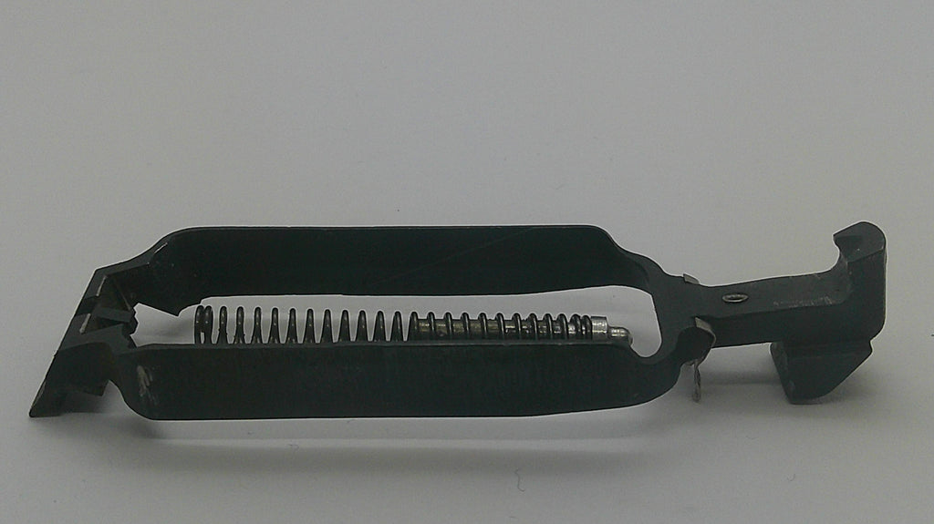 A black metal firearm magazine component with a visible coiled spring, photographed on a plain light gray background.