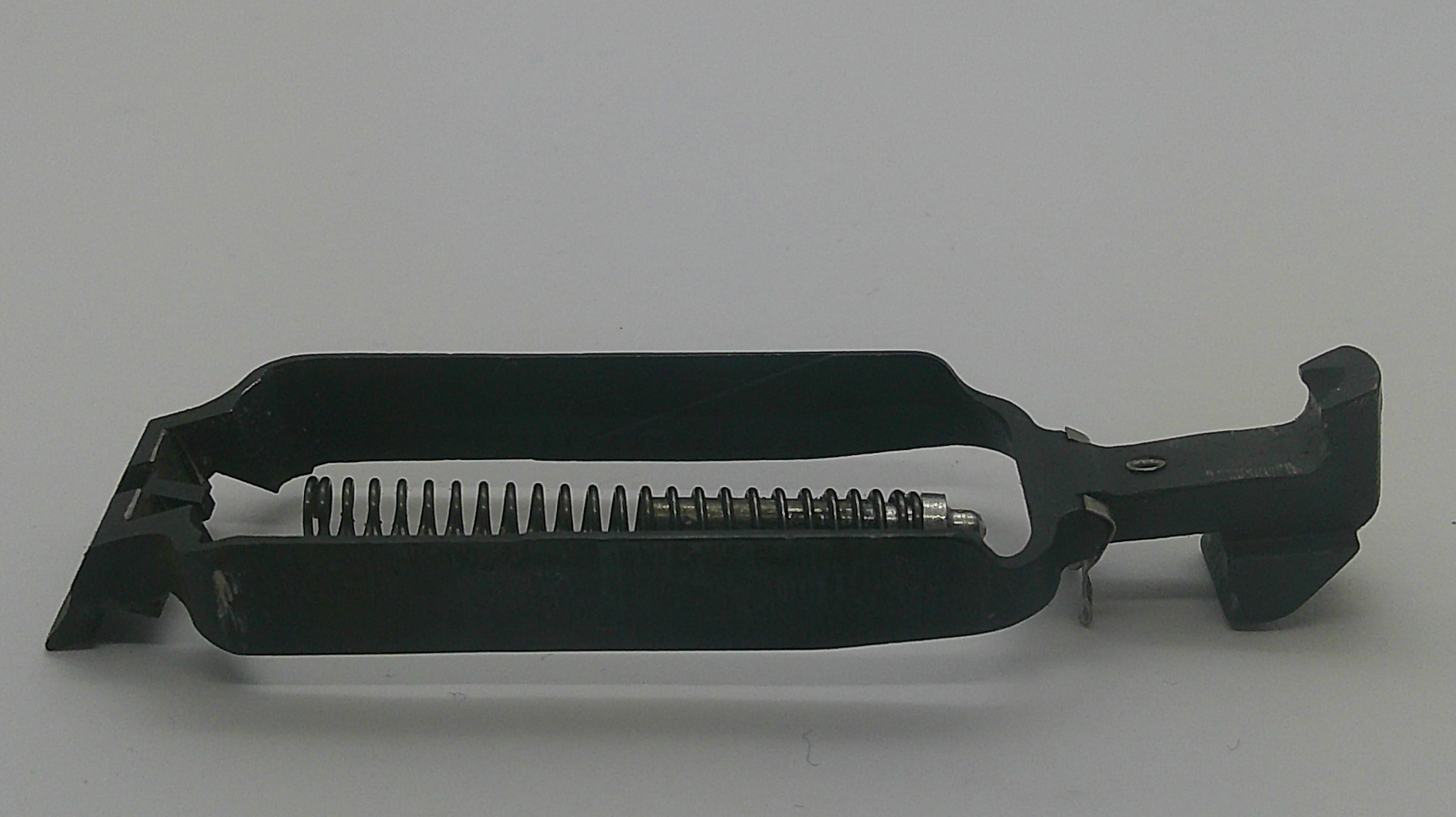 A black metal firearm magazine component with a visible coiled spring, photographed on a plain light gray background.