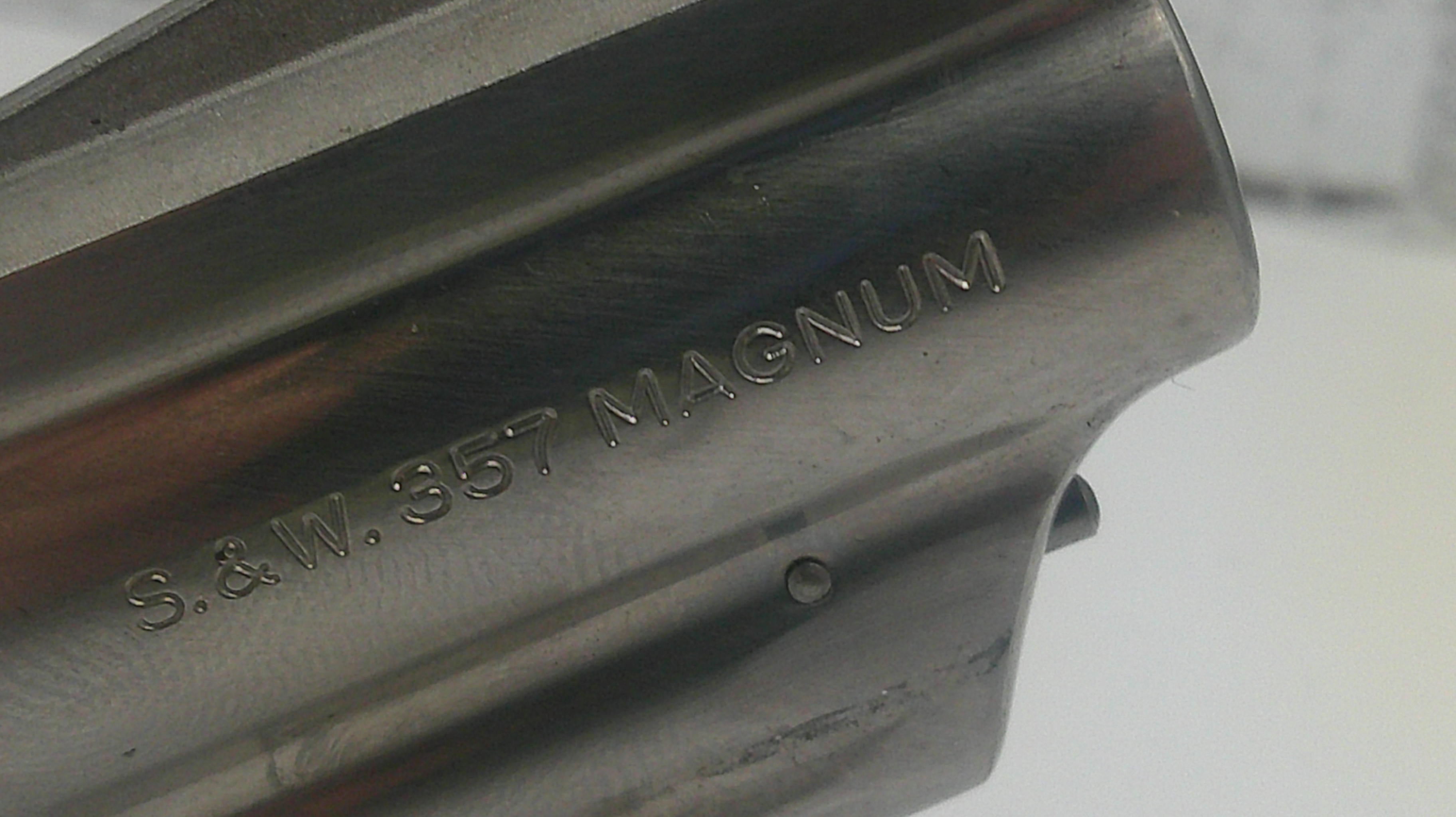 Close-up of a metallic object with 'S.&W. 357 Magnum' engraving on a blurred background