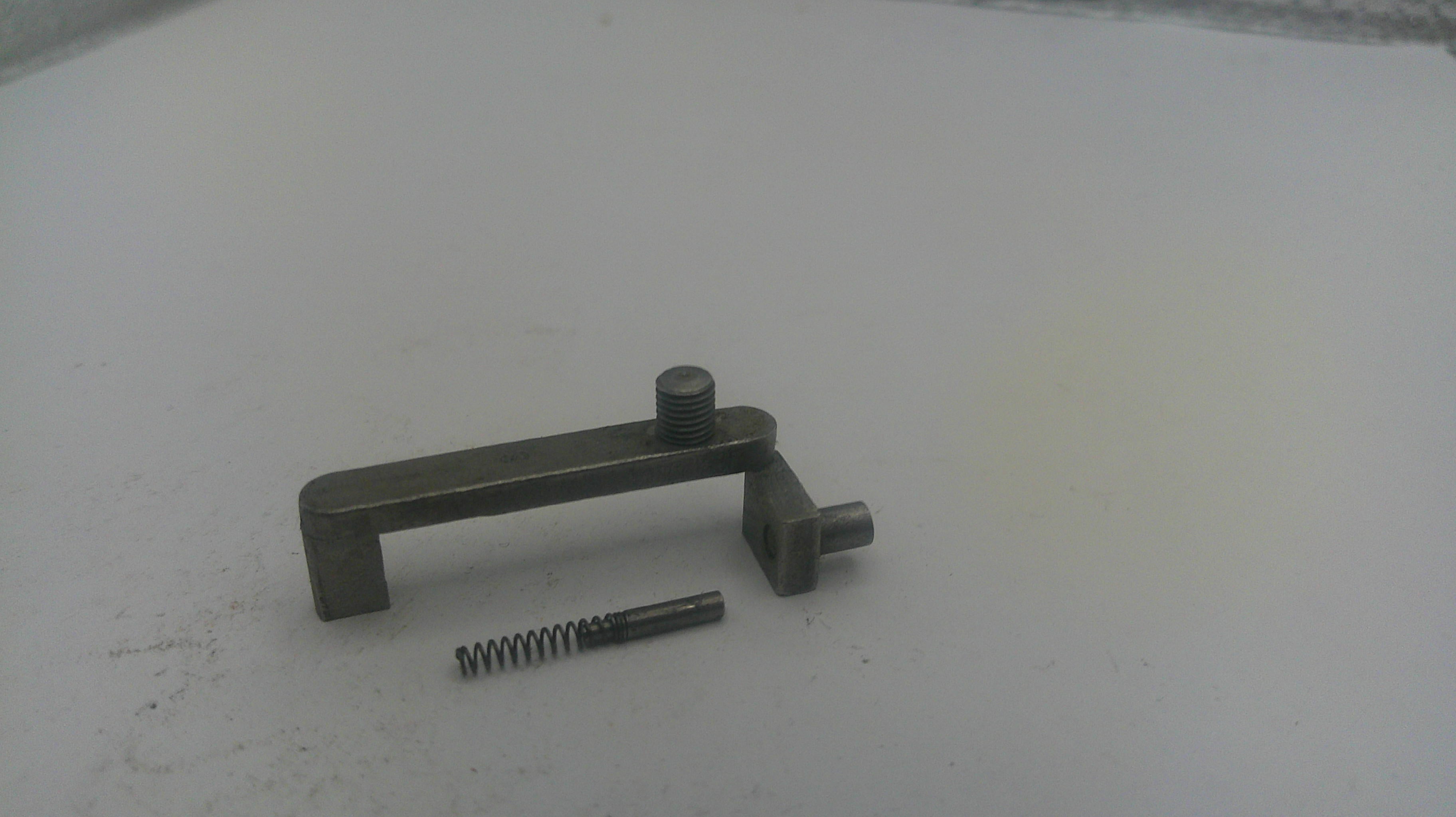 Metal lever and screw on a white surface