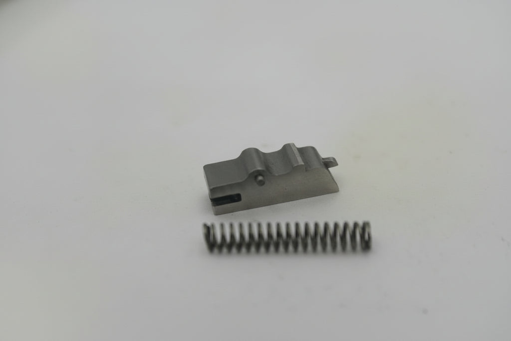 Small mechanical component and spring on a white surface