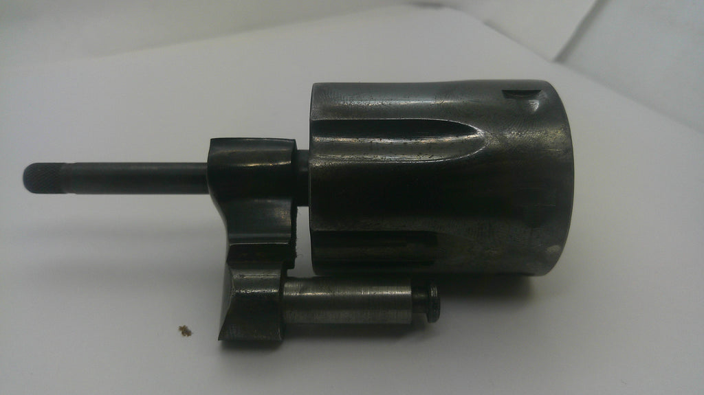 A dark metallic mechanical component, likely a lock cylinder or gun lock part, shown on a plain white background.