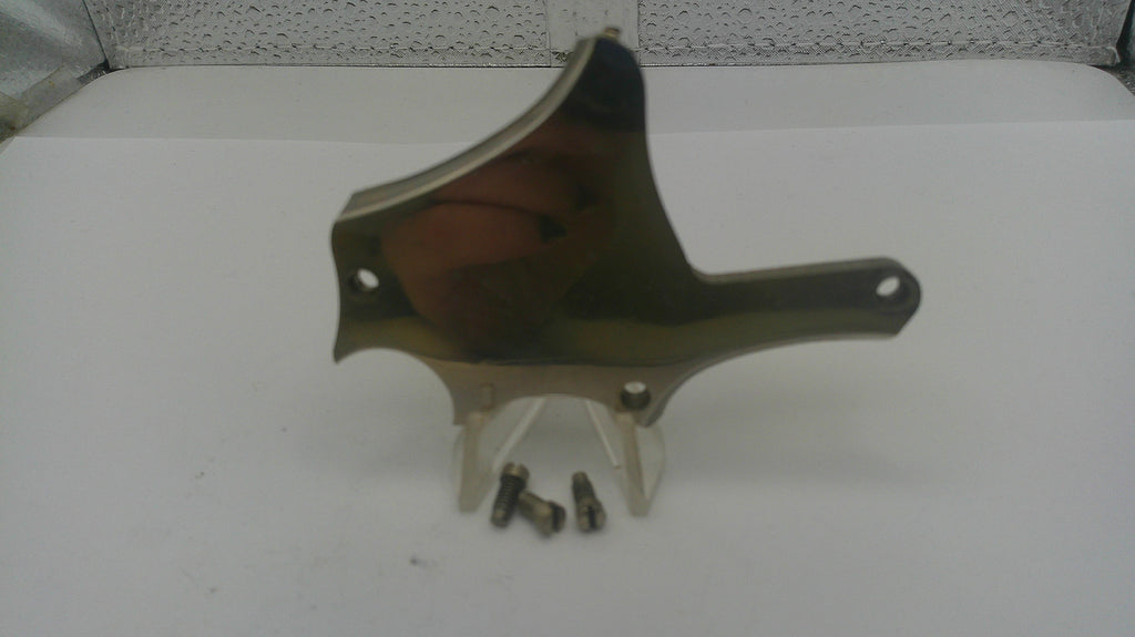 Metallic object on a white surface with a textured gray background