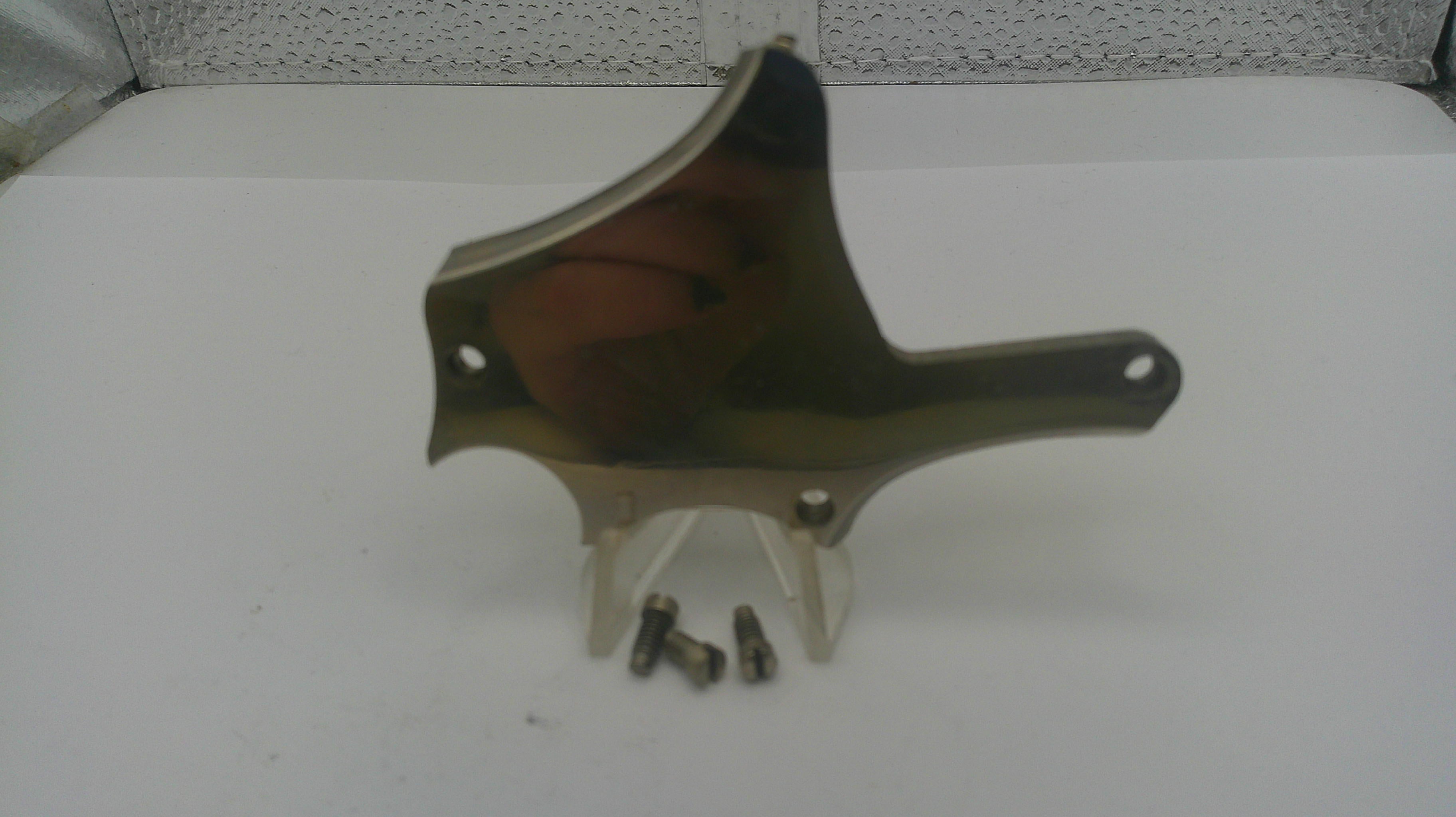 Metallic object on a white surface with a textured gray background
