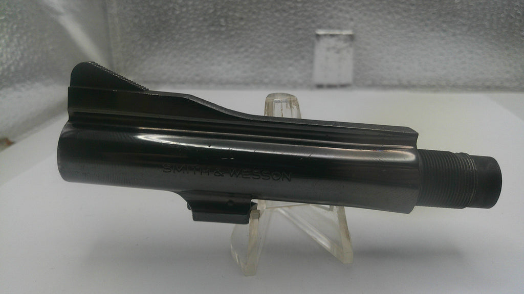 Black metal component on a stand against a neutral background