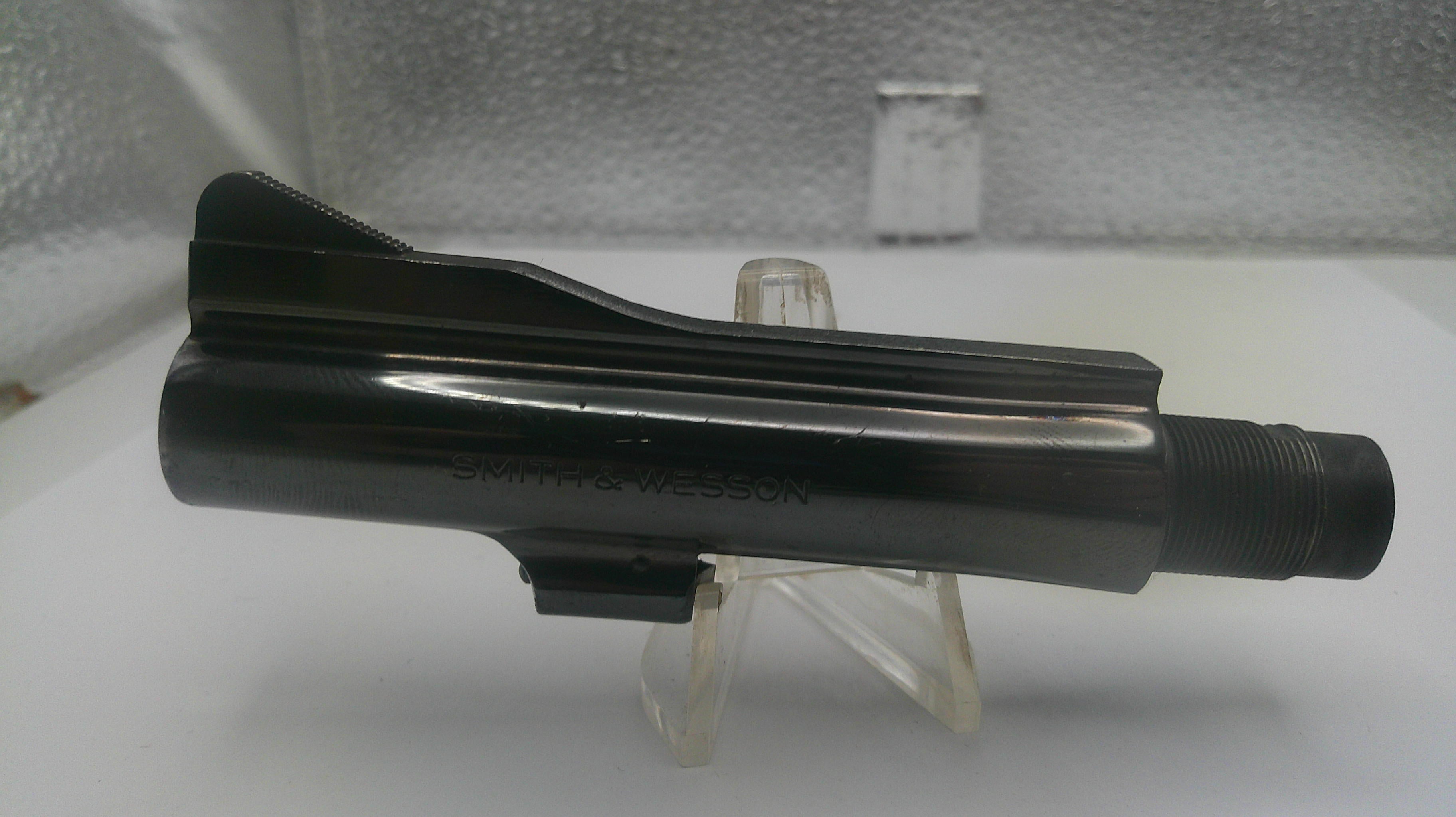 Black metal component on a stand against a neutral background