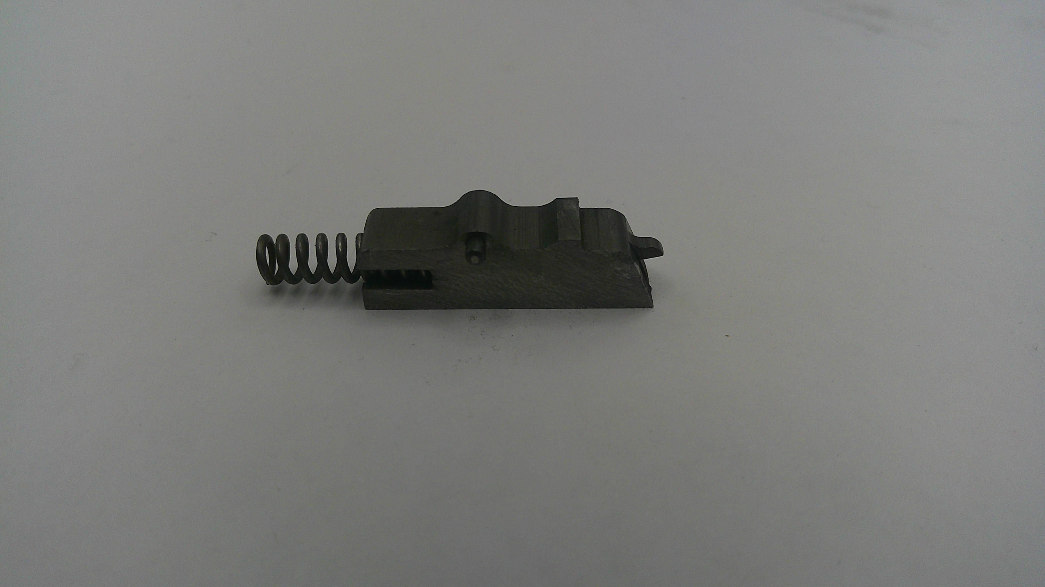 Black metal component with a spring on a white background
