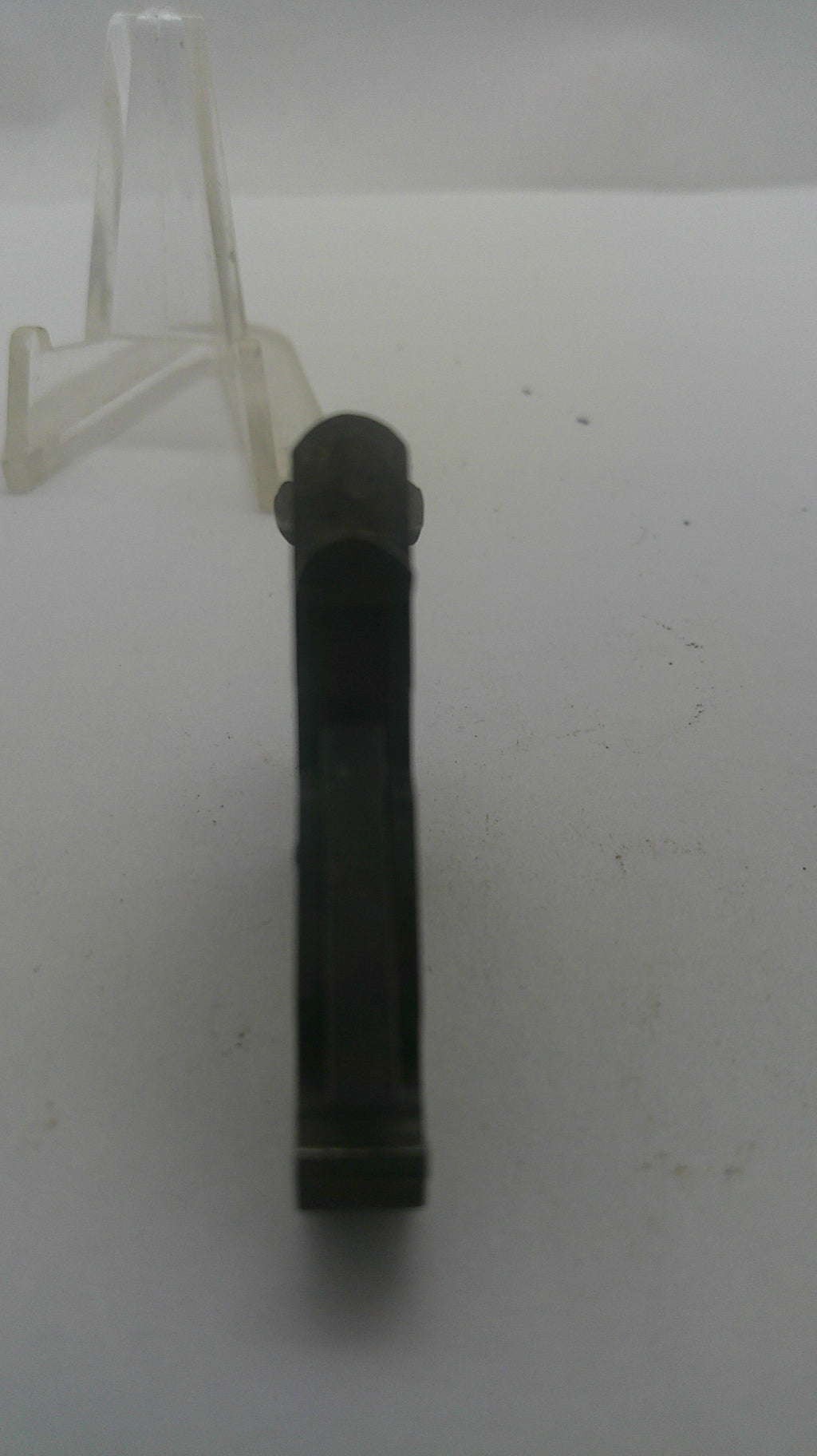 A black plastic cylindrical component, possibly a connector or clip, shown horizontally on a plain white surface.