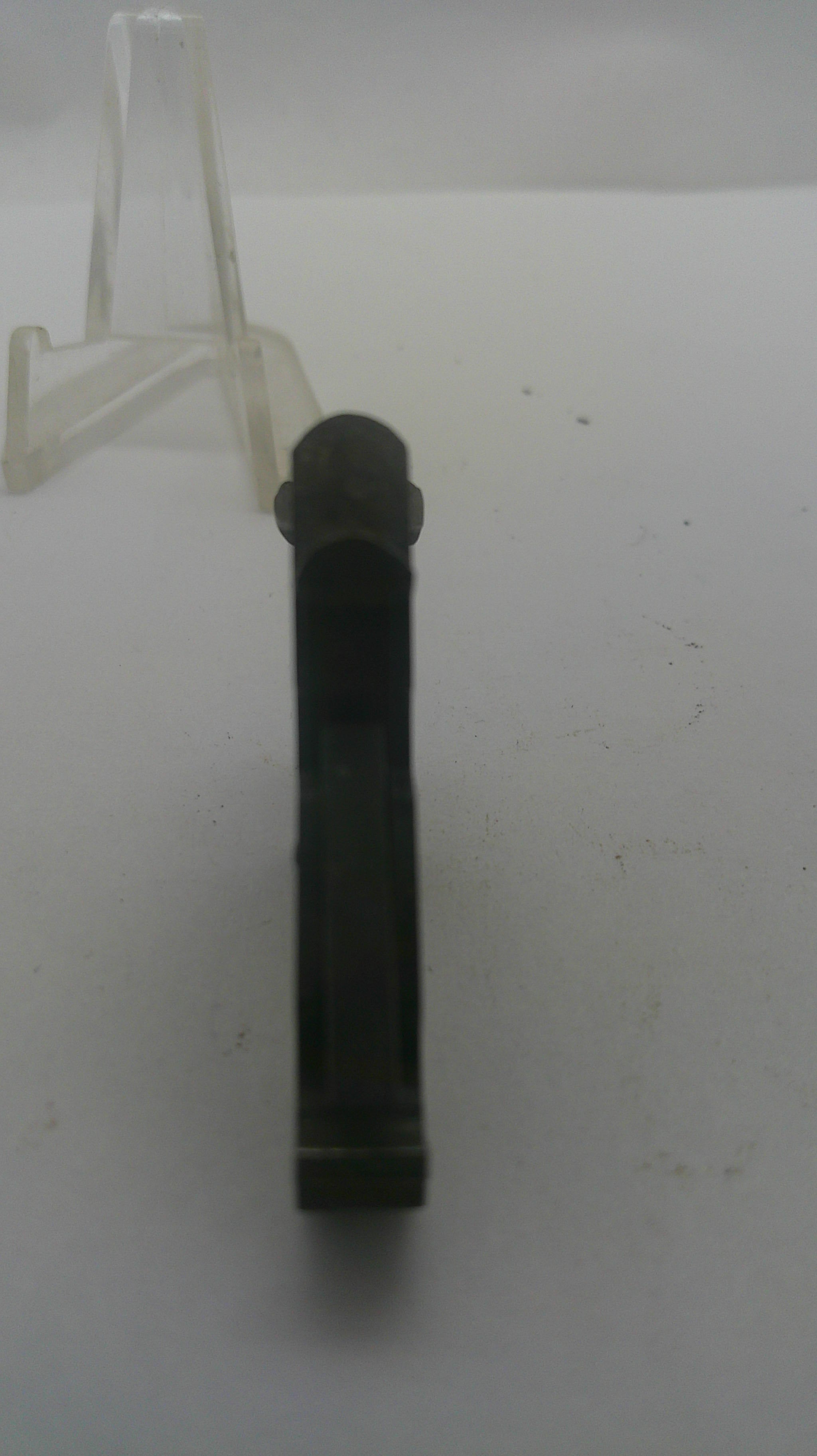 A black plastic cylindrical component, possibly a connector or clip, shown horizontally on a plain white surface.