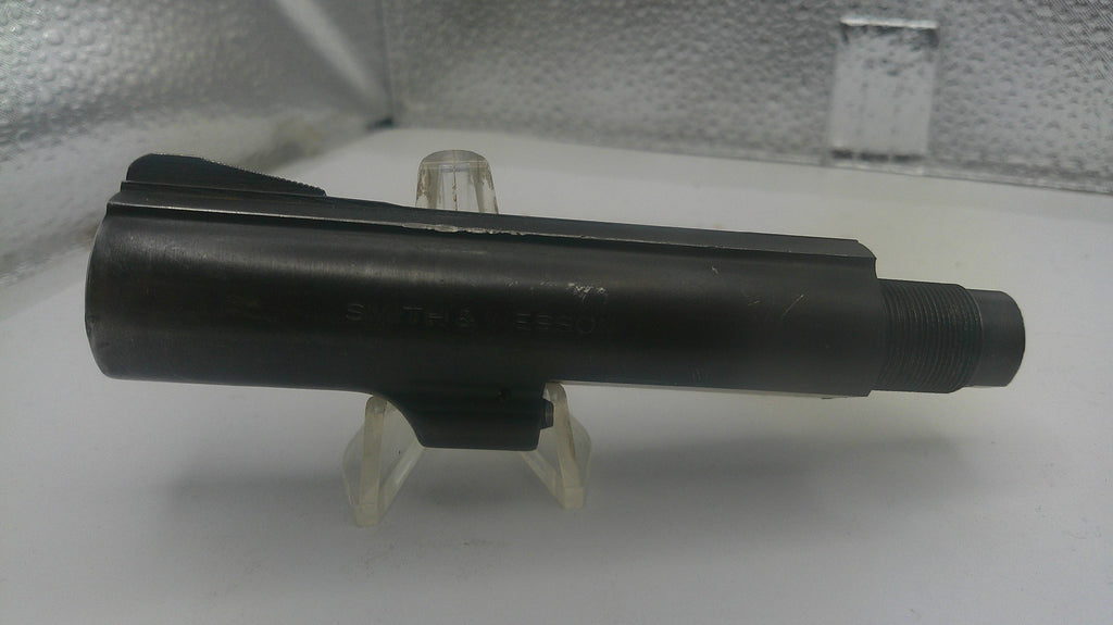 Black metal component on a white stand with a textured background