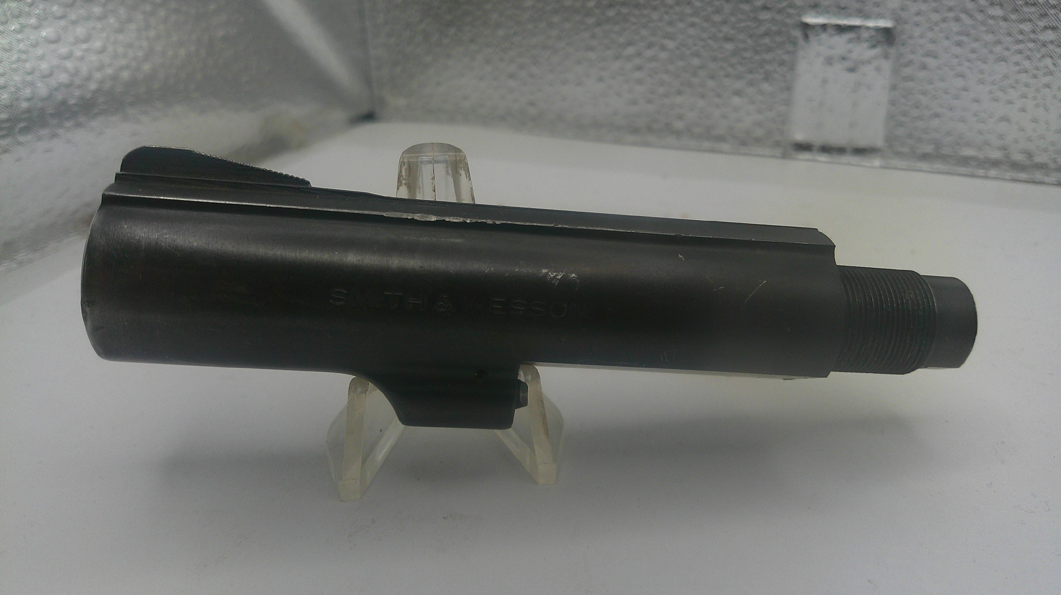 Black metal component on a white stand with a textured background