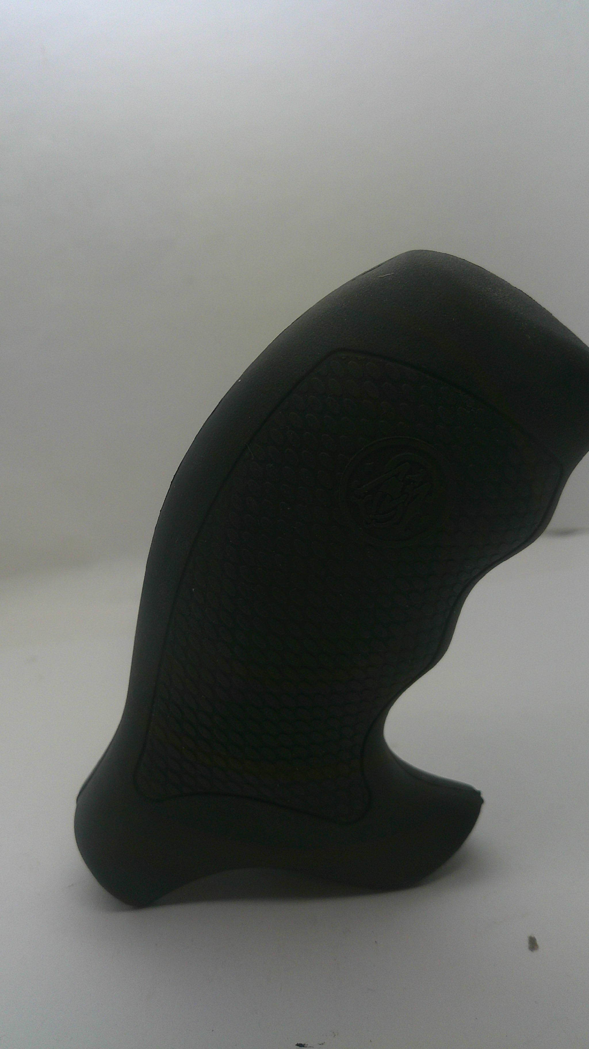 A black textured grip cover or foam insert with a curved ergonomic shape, shown against a plain off-white background.