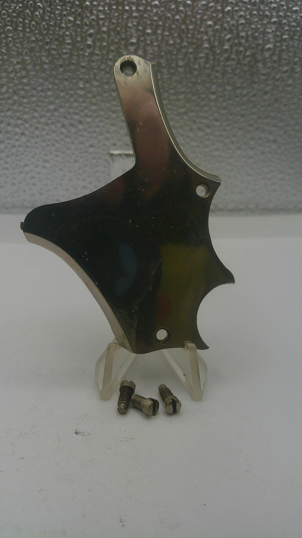 Violin bridge with saddle on a textured surface
