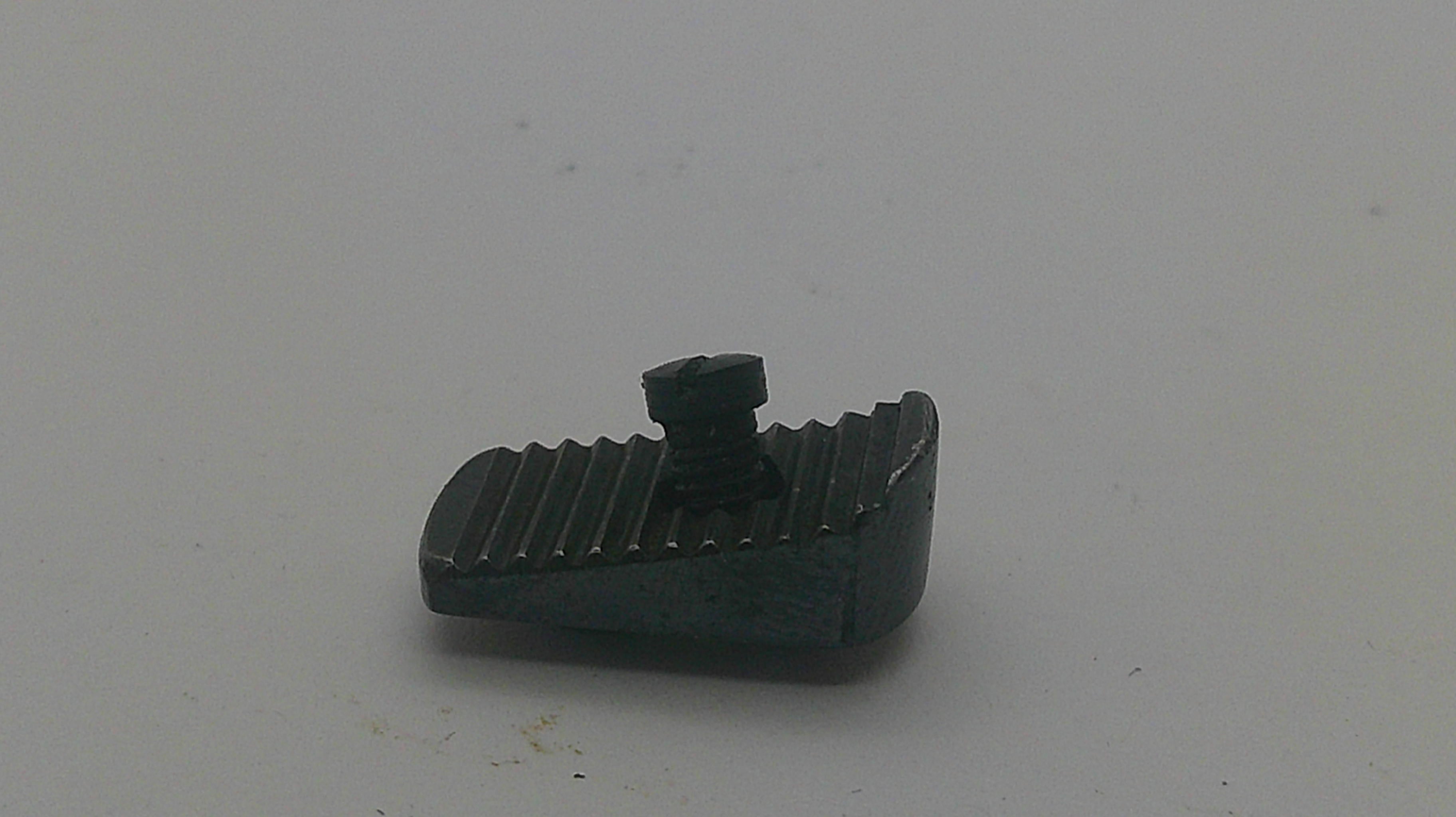 A small black metal threaded component with a ribbed top surface, photographed on a plain light gray background.